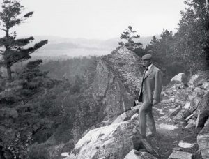 George Dorr standing in Acadia National Park and looking into the distance.